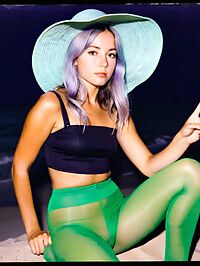 A silver haired 20 year old woman with blue eyes lounges on the moonlit beach in vintage attire